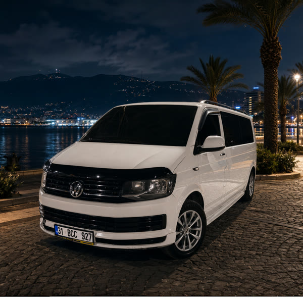 İskenderun sahilinde beyaz VIP transfer minibüsü, gece ışıkları
